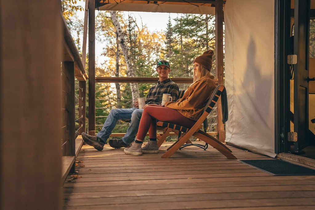 couple sitting by a glamping tent