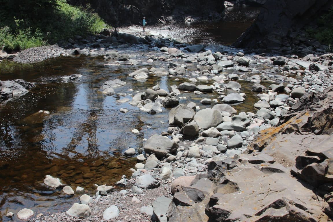 Riverside with rocks and person in distance.