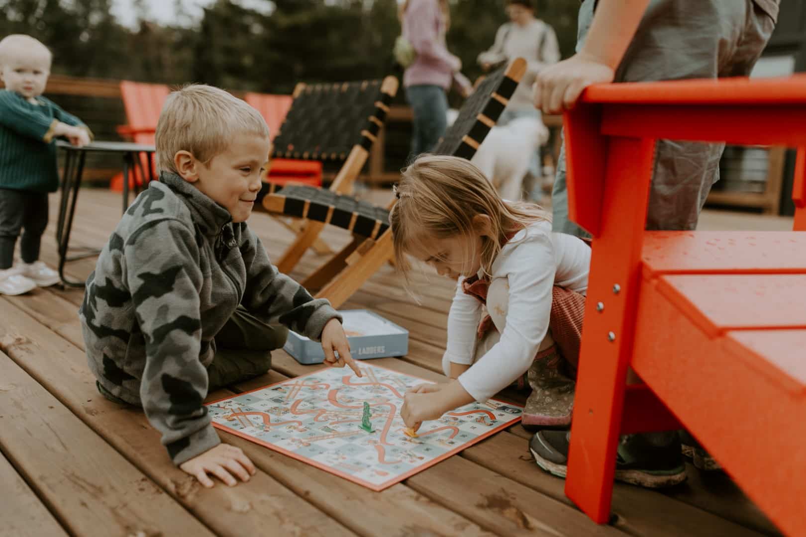 Children playing a board game outdoors.