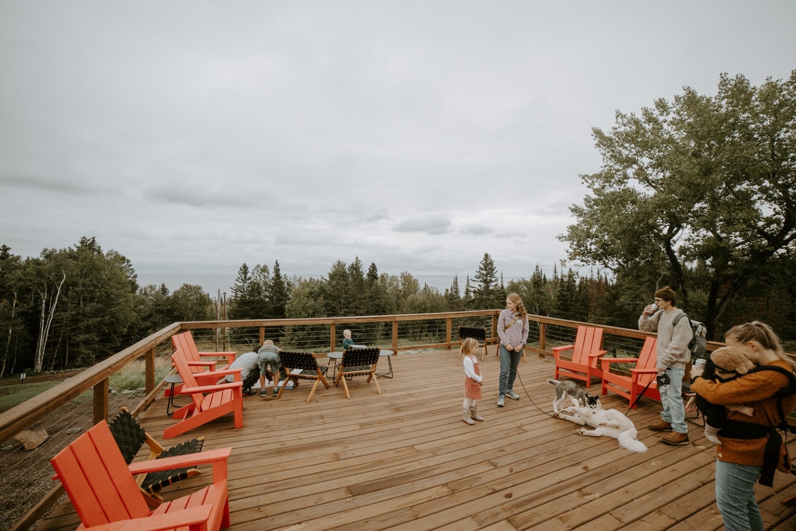 Family and dog on scenic wooden deck.