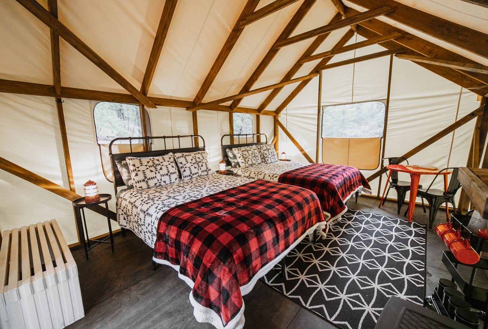 Cozy glamping tent interior with two beds.