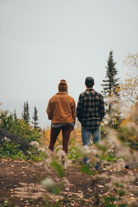 Two people hiking in autumn forest scenery.