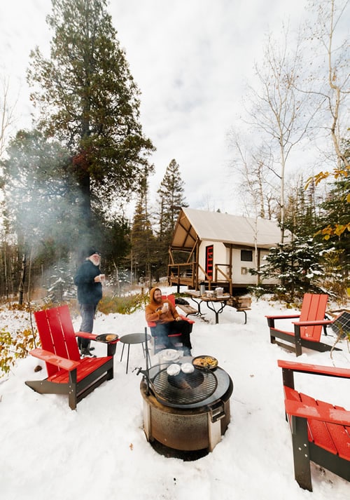 Winter camping with friends at a cozy forest retreat.
