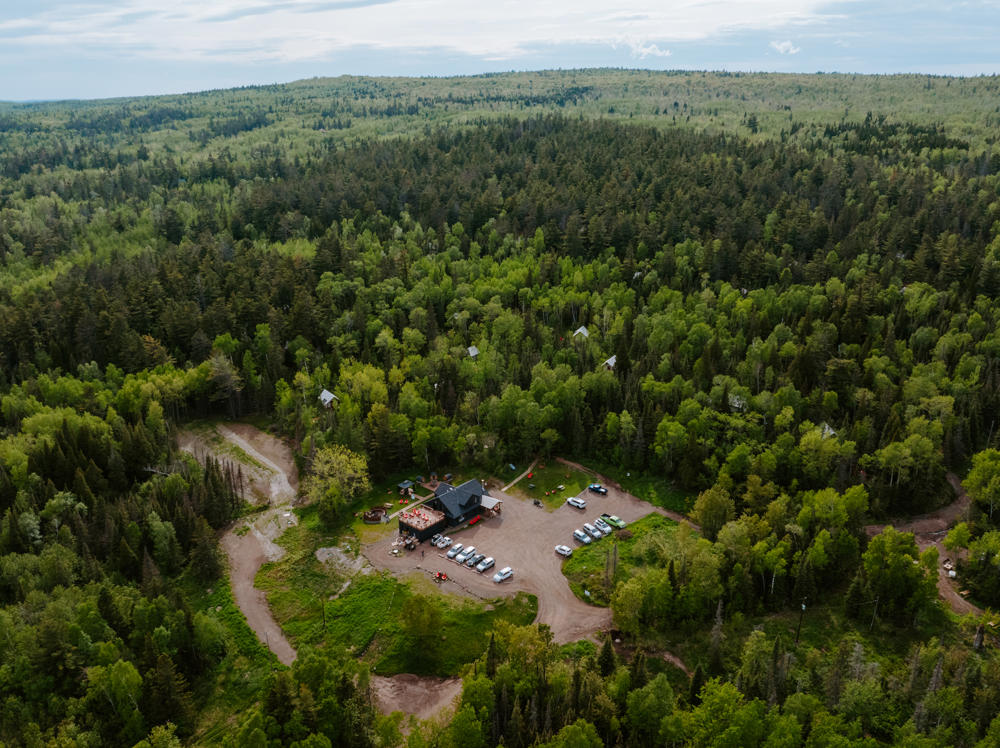 Aerial view of forest lodge and parking lot.