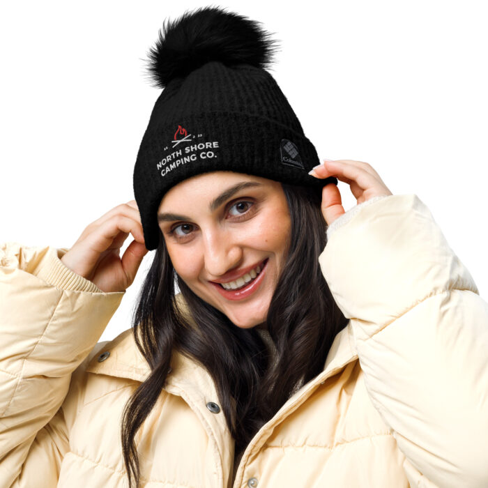 Smiling person in winter hat and puffer jacket.