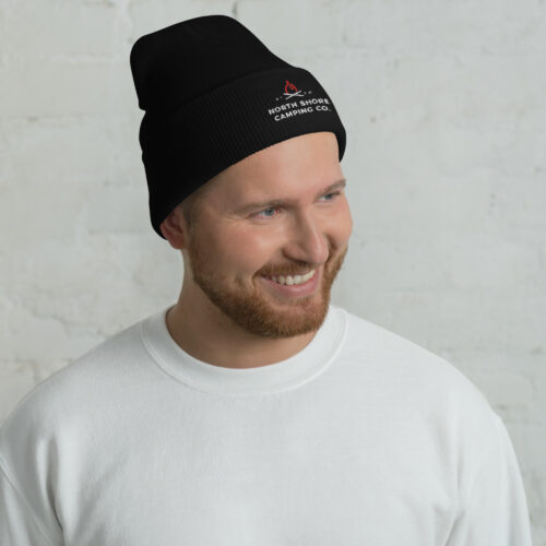 Smiling man wearing black beanie and white sweater.