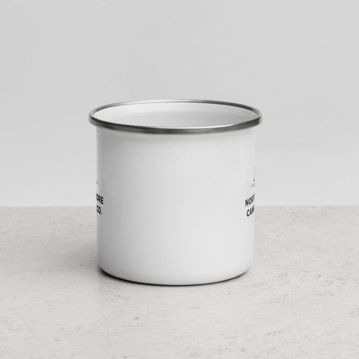 White enamel camping mug on light surface