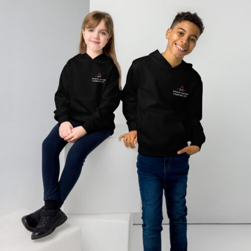 Kids wearing black hoodies and jeans smiling.