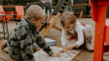 Children playing with board game on deck.