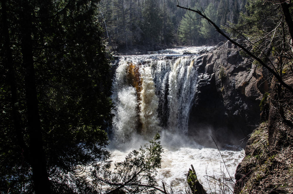 Scenic waterfall in forested landscape.