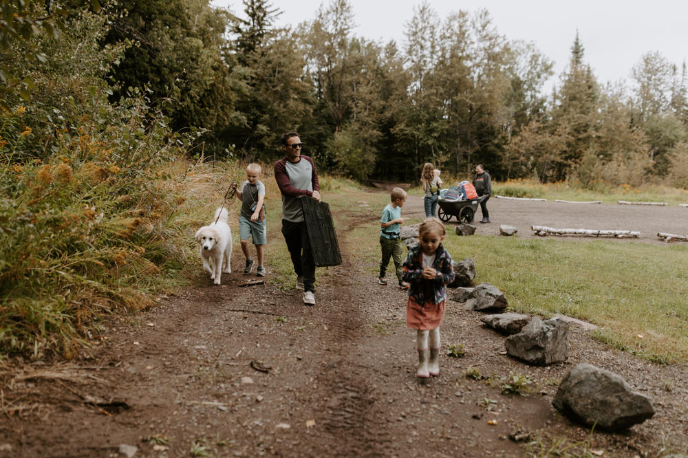 Family and dog walking in forest park trail.