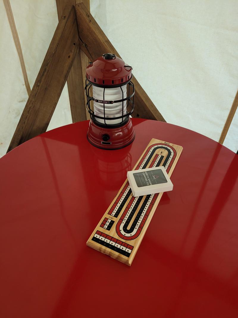 Red lantern and cribbage board on red table.
