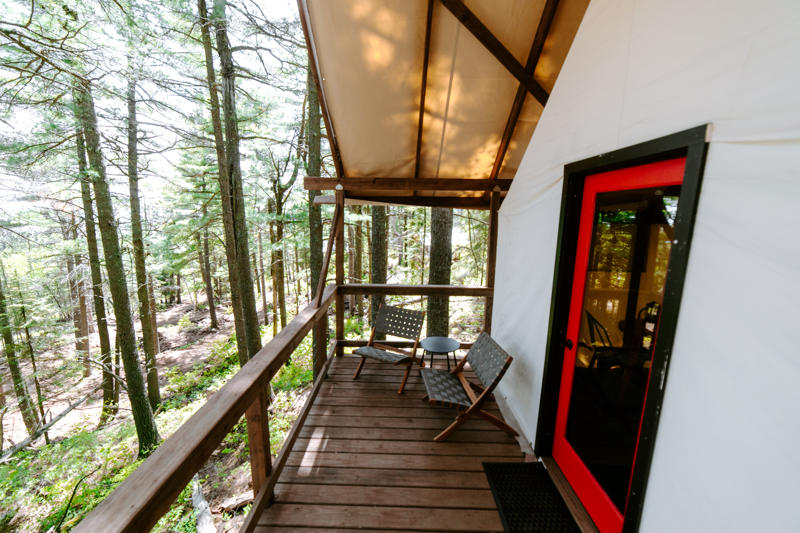 Cabin porch in forest setting with chairs