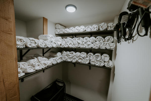 nscc 0923 144 Linen closet with neatly stacked white towels.