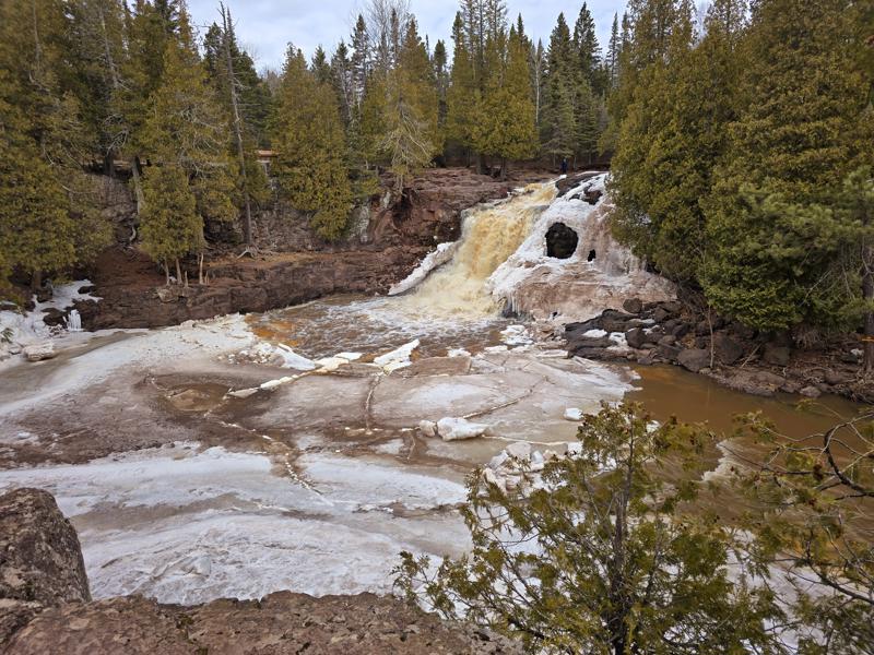 Frozen waterfall surrounded by evergreen trees