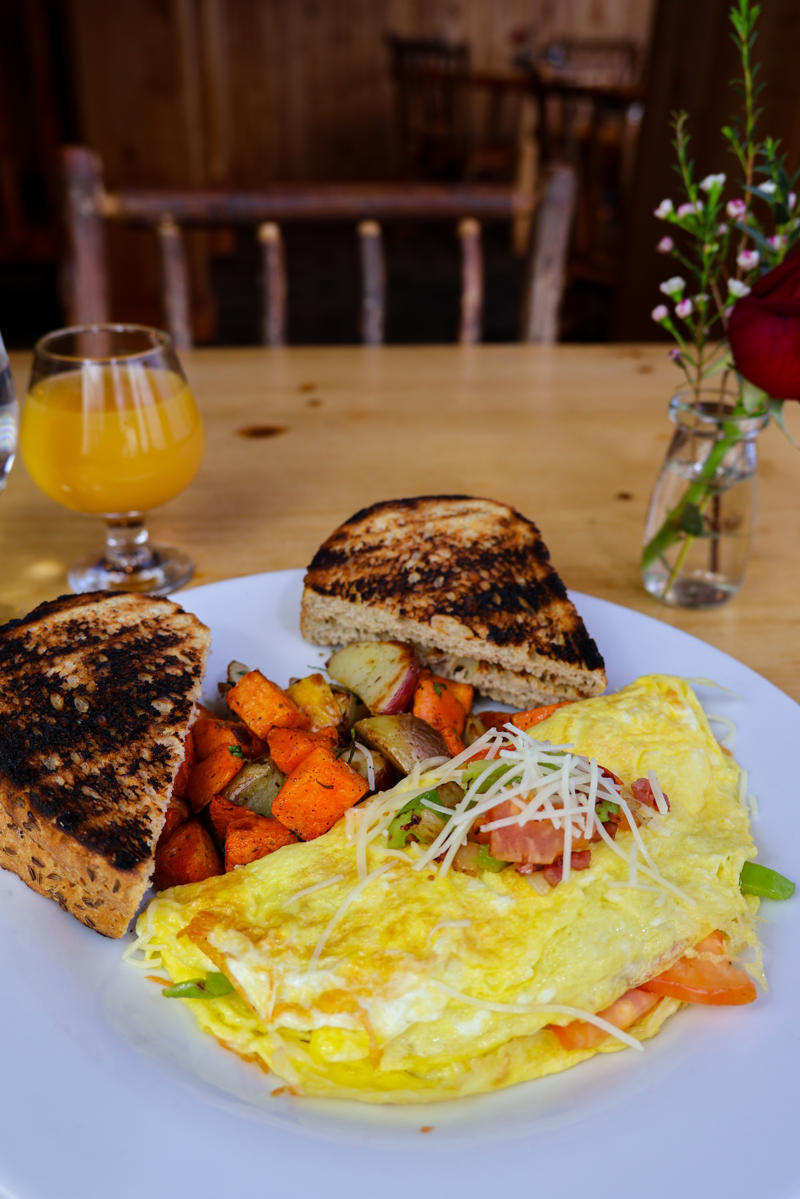 Vegetable omelette with toast and roasted veggies.