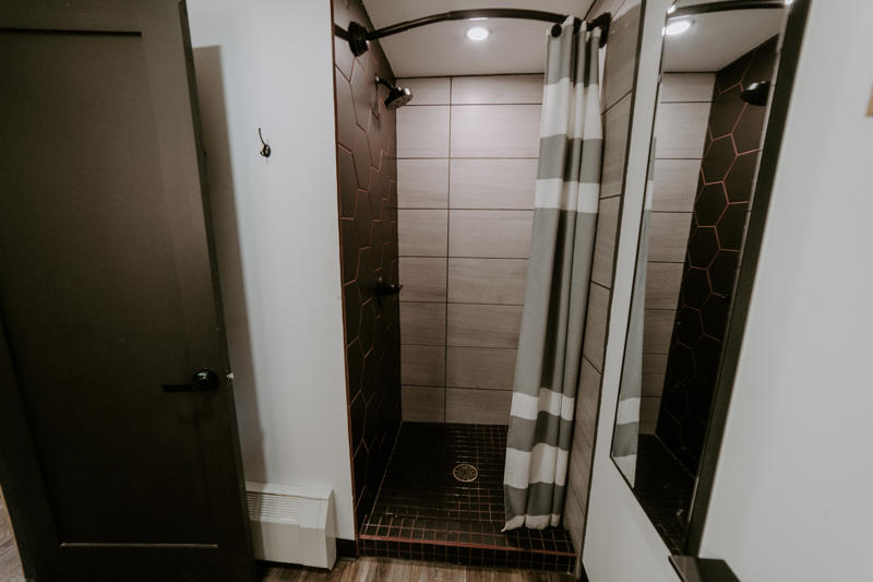Modern shower with curtain and hexagonal tiles.