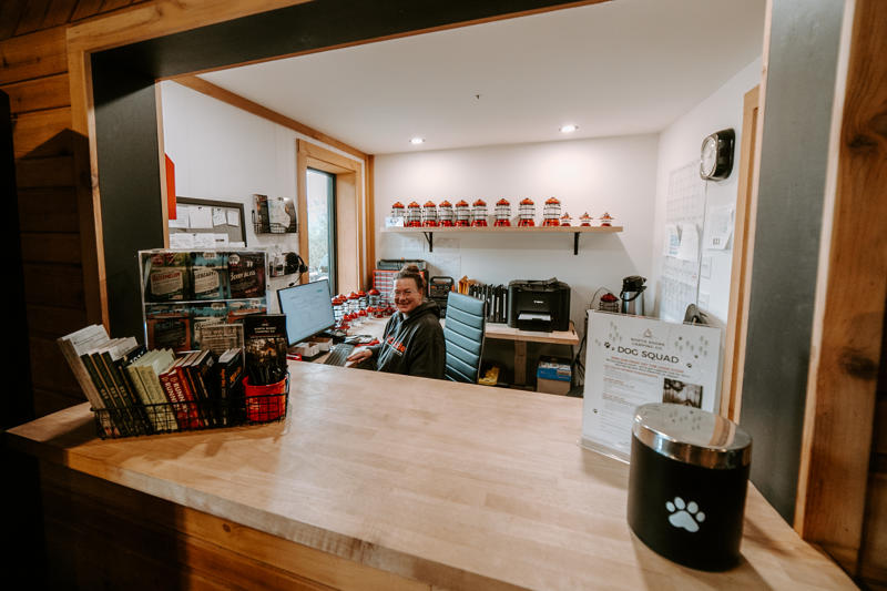 Person working at a reception desk with books.