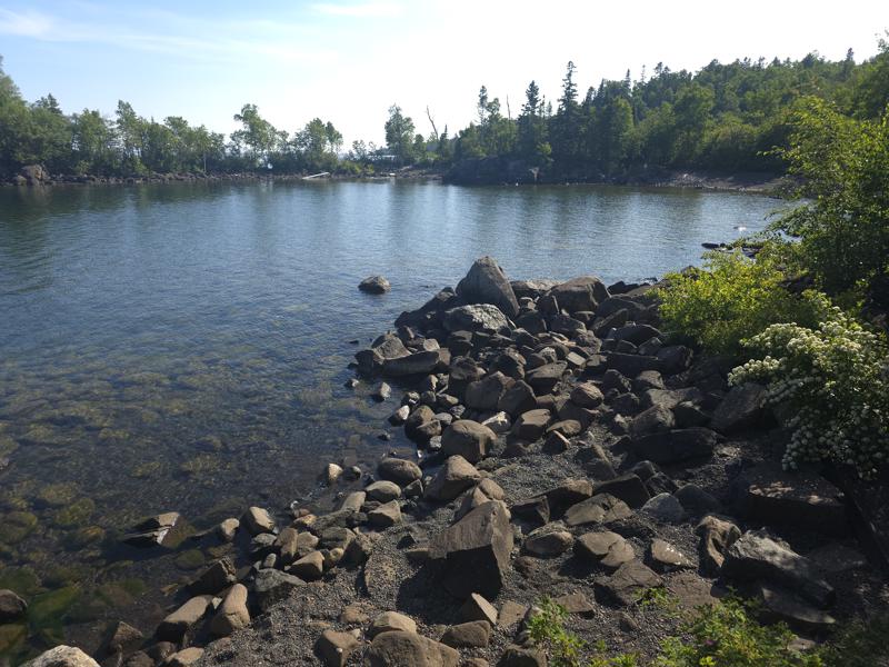 20250709 172537 Rocky lakeside with trees and clear water