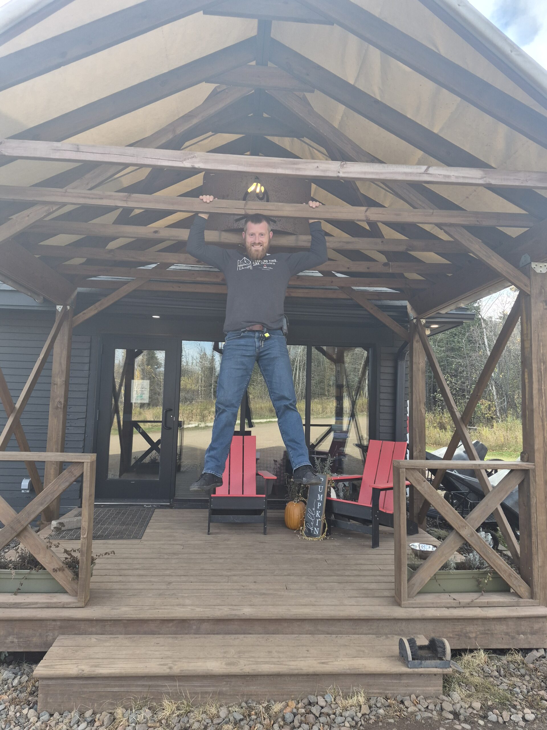 Person doing pull-up on porch beam.