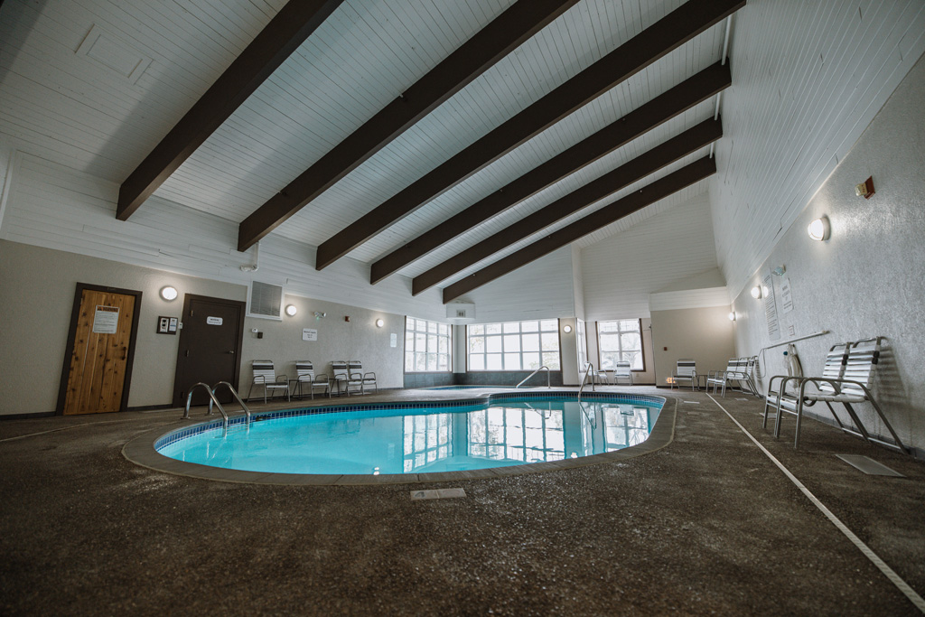 covepointlodge fall2022 images 378 Indoor pool with seating and large windows.