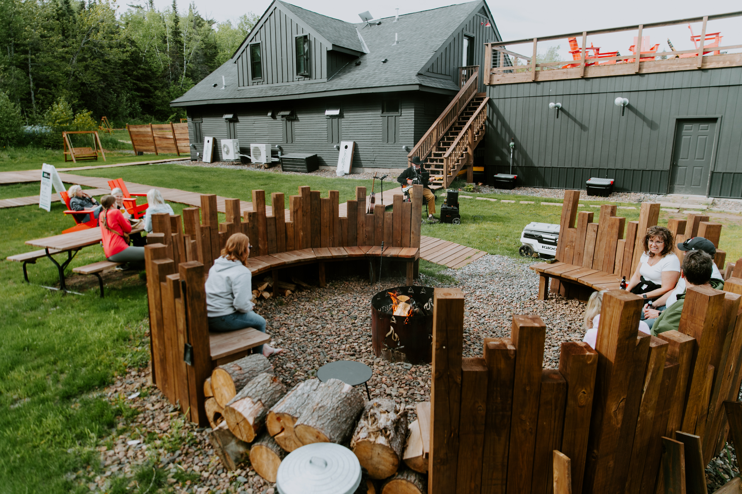 People socializing in outdoor fire pit area.