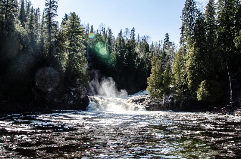 dsc 0198 Waterfall surrounded by evergreen forest on a sunny day.