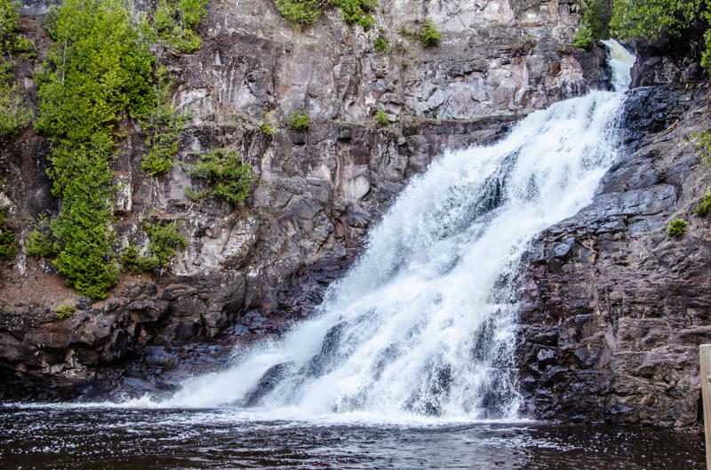 dsc 0258 (1) Waterfall cascading over rocky cliff with trees.