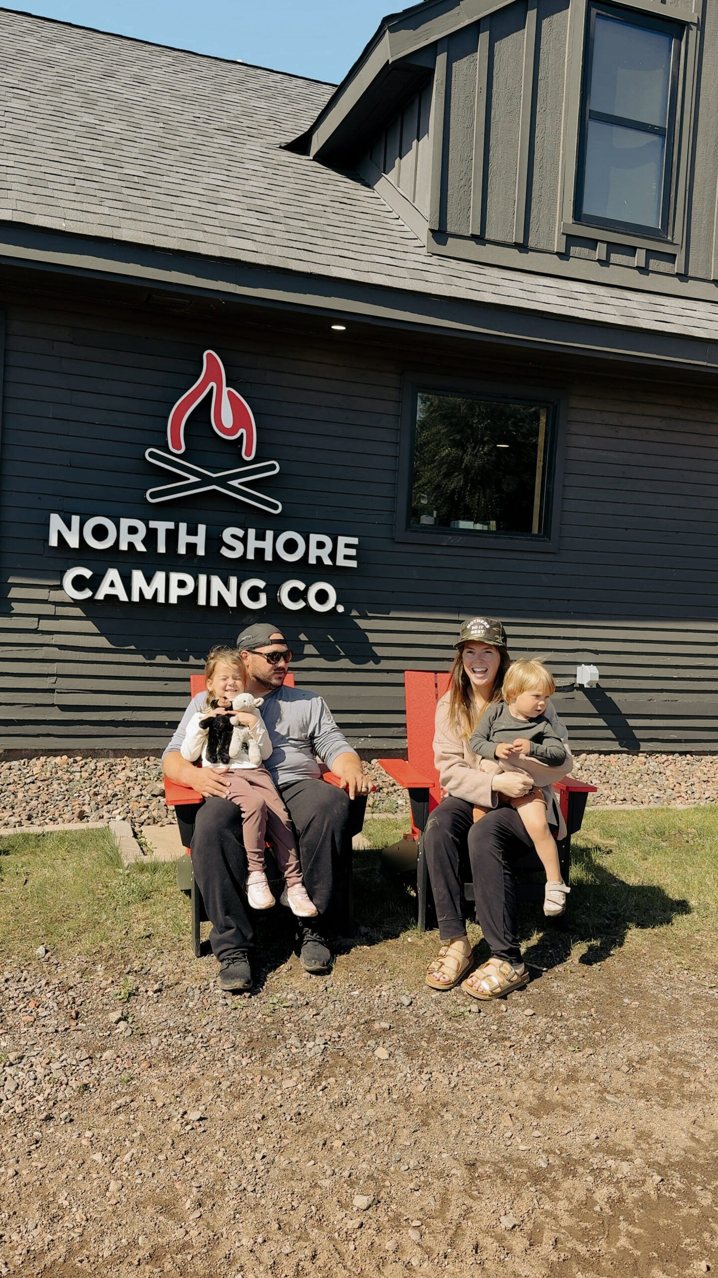familyinfrontofbaselodge (1) Family sitting outside North Shore Camping Co. building.