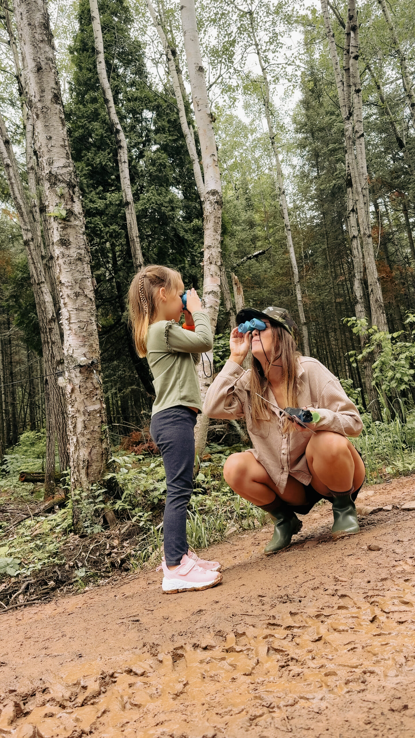 girl&mombinoculars (2) Woman and child using binoculars in forest trail.
