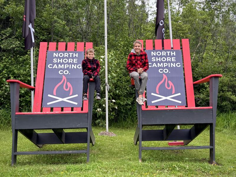 img 5867 Children sitting on giant camping chairs outdoors.