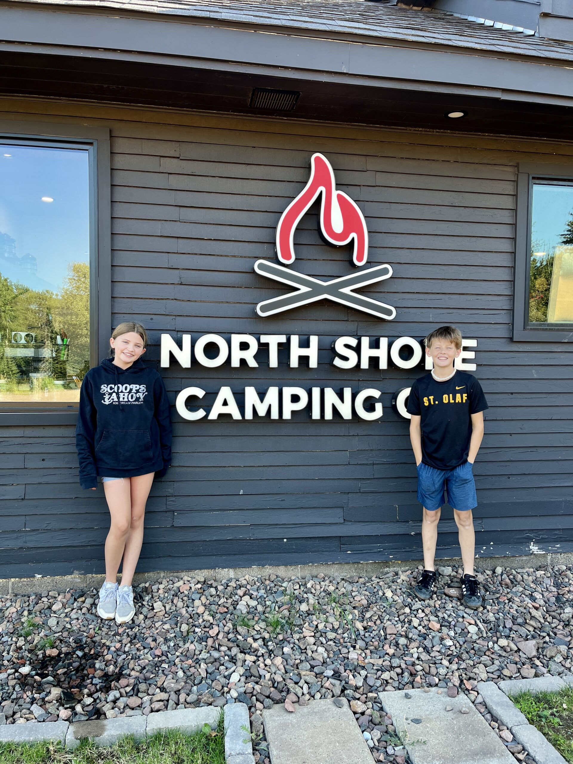 img 8119 (1) Children stand by North Shore Camping Co. sign.