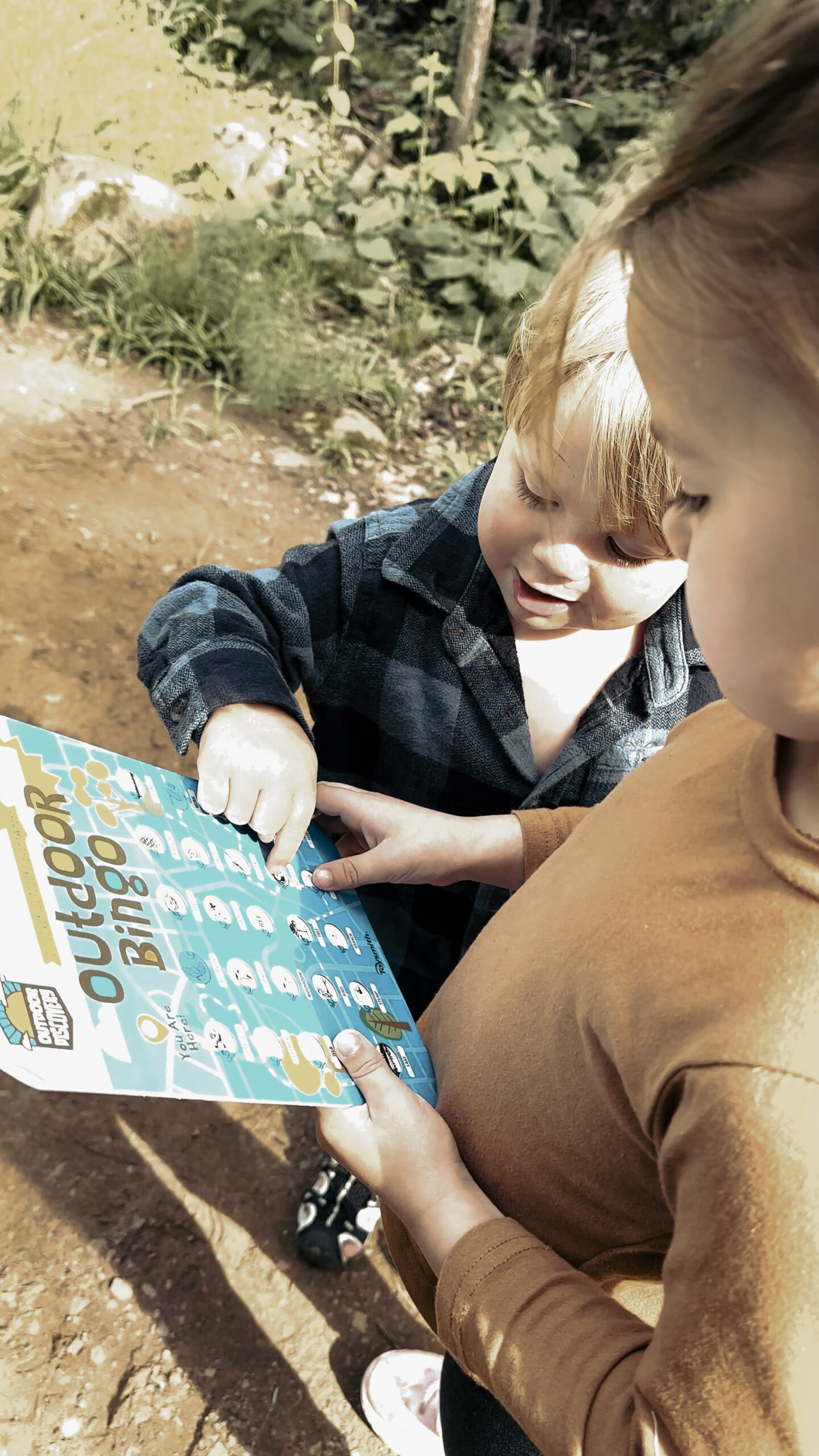 kidsoutdoorbingo (1) Children playing outdoor bingo in nature.