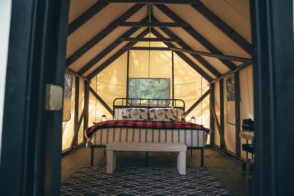 Cozy cabin interior with rustic bed and decor.
