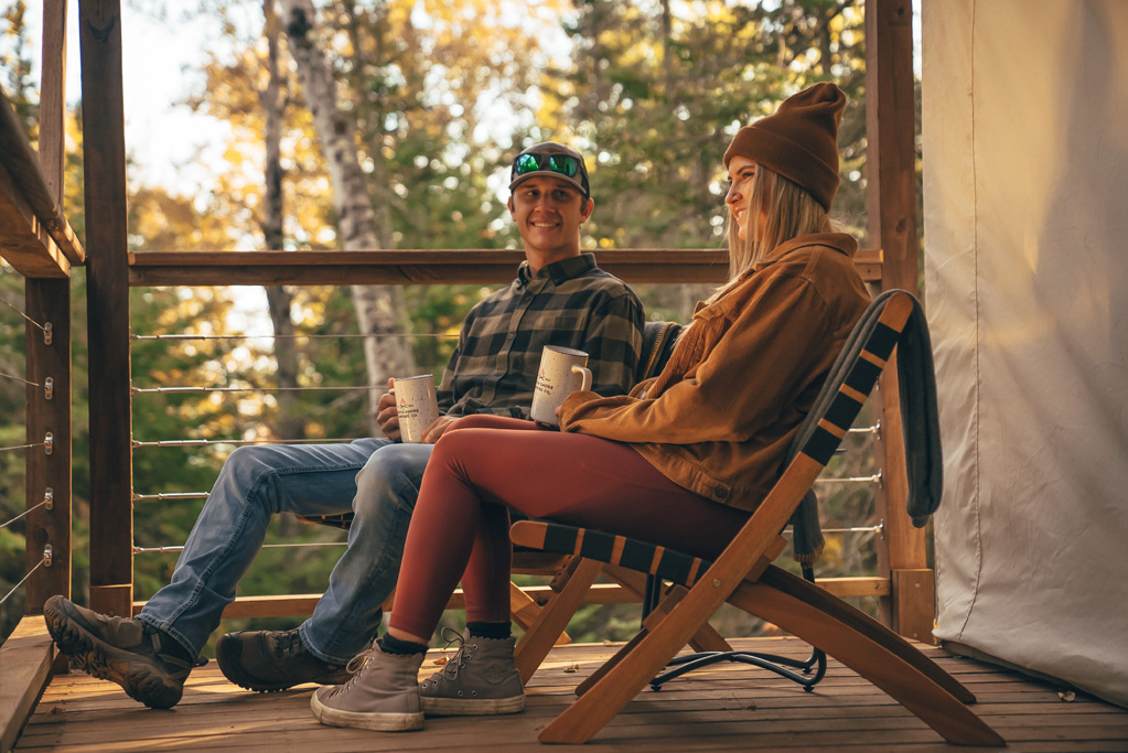 Couple relaxing on porch with coffee.