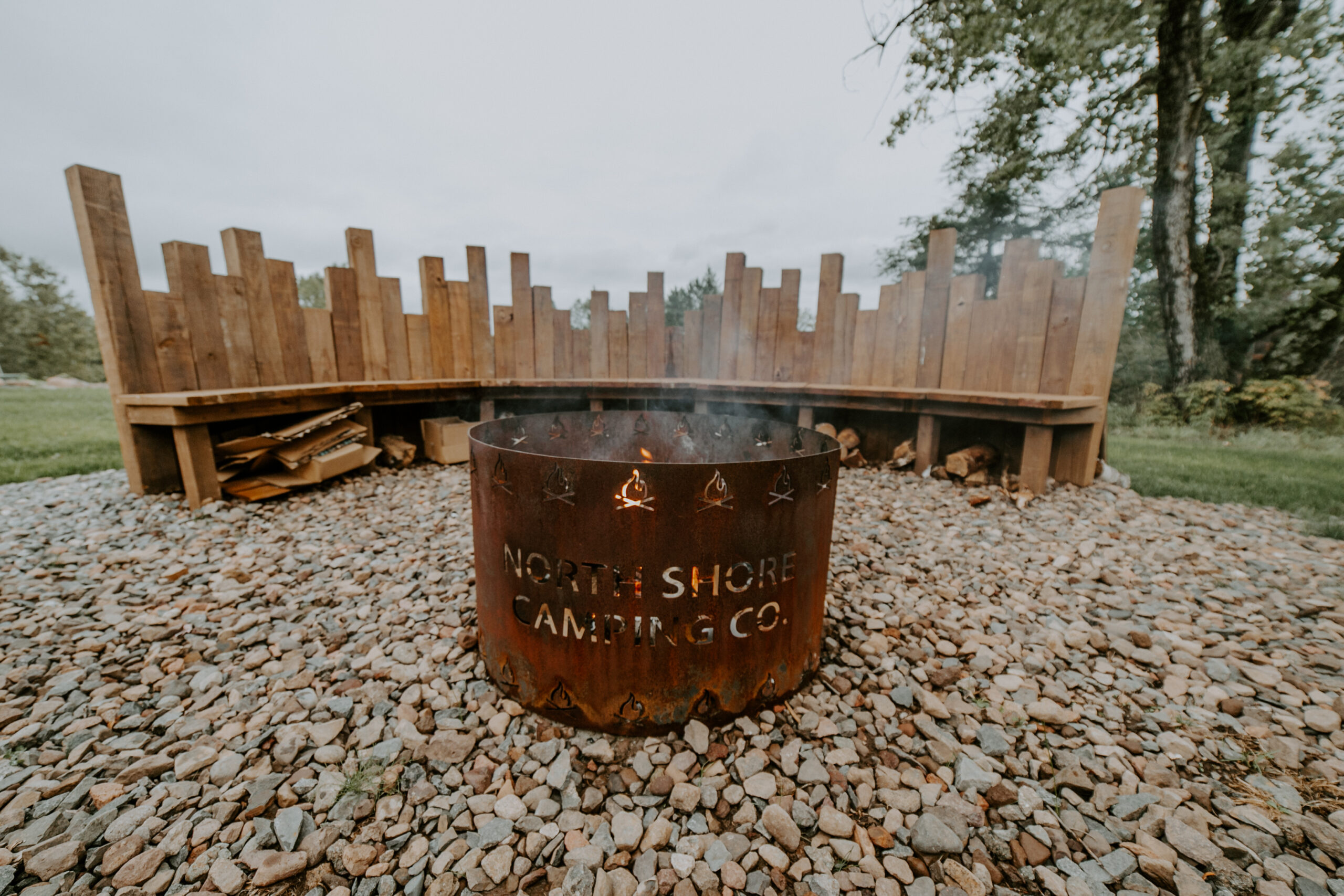 Outdoor fire pit with wooden seating area.