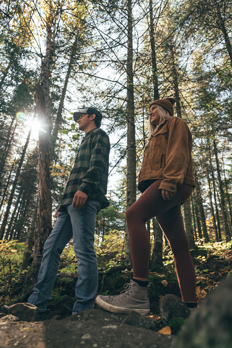 northshorecampingco fall2022 images 18 Two hikers walking through sunlit forest trail